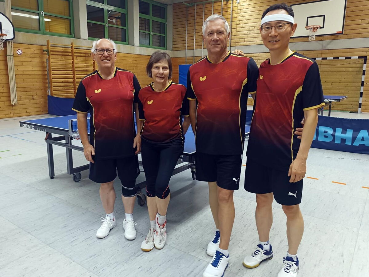 Fünf Mitglieder des Turnvereins Landshut stehen in einheitlichen Trikots vor einem Tischtennistisch.