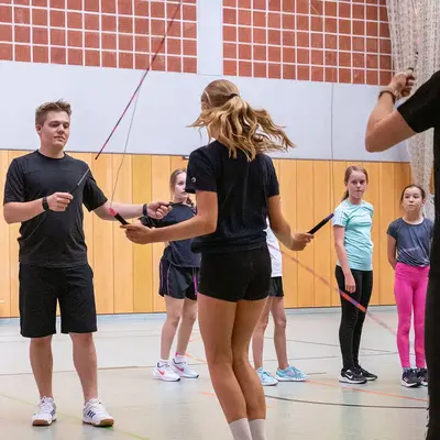 In einer Turnhalle der Turngemeinde Landshut üben junge Sportler mit einem Springseil gemeinsam ihre Technik.