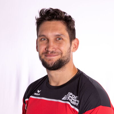 Ein Mann im Sporttrikot lächelt in die Kamera, repräsentierend die Turngemeinde Landshut.