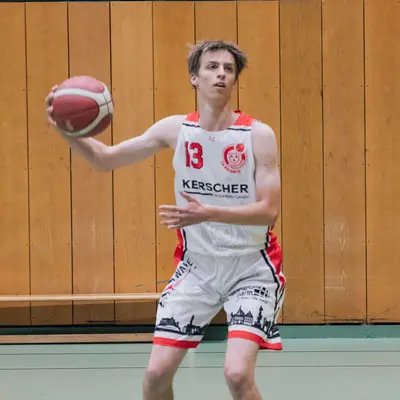 Ein Basketballspieler des TGL-Vereins dribbelt konzentriert in der Halle von Landshut.