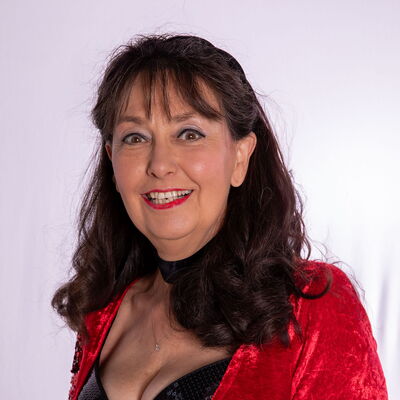 Eine lächelnde Frau im TGL-T-Shirt repräsentiert stolz ihren Sportverein.