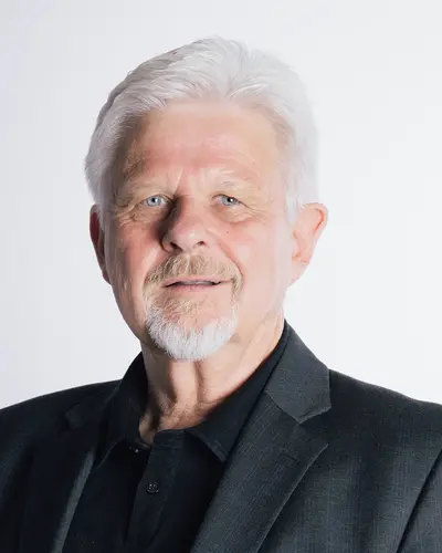 Protokollführer Werner Siegl mit weißem Haar und Bart trägt einen dunklen Anzug und repräsentiert den Sportverein der Turngemeinde Landshut.