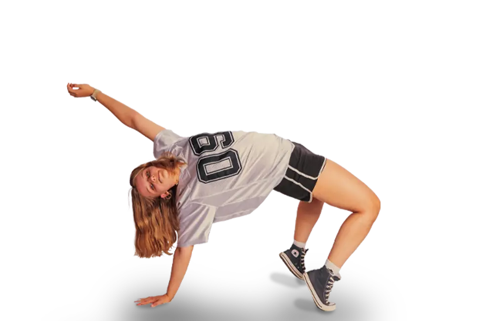 Eine junge Frau in Sportkleidung macht eine dynamische Tanzbewegung, die an ein Turngemeinde-Training erinnert.