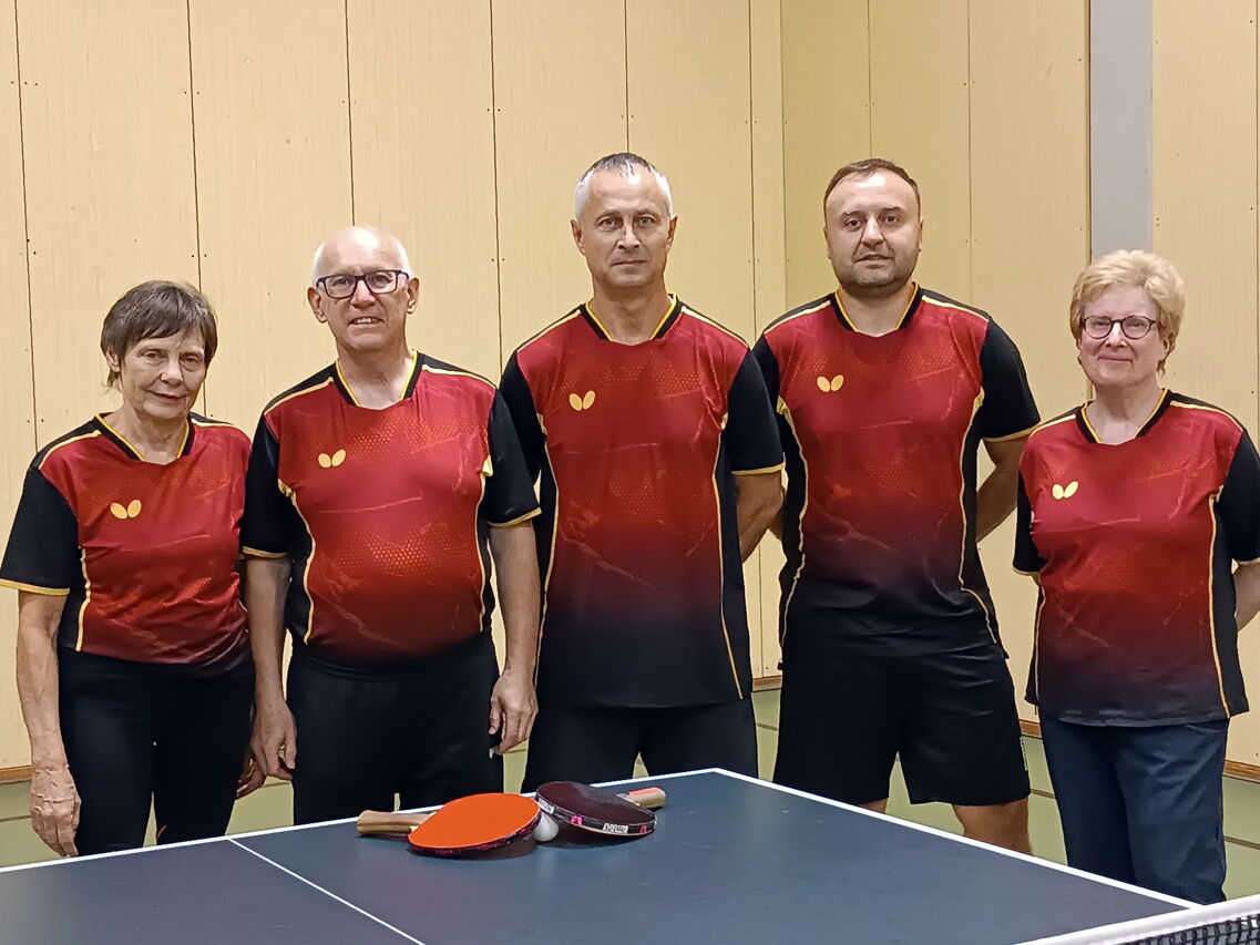 Fünf Mitglieder des Turnvereins Landshut stehen in einheitlichen Trikots vor einem Tischtennistisch.