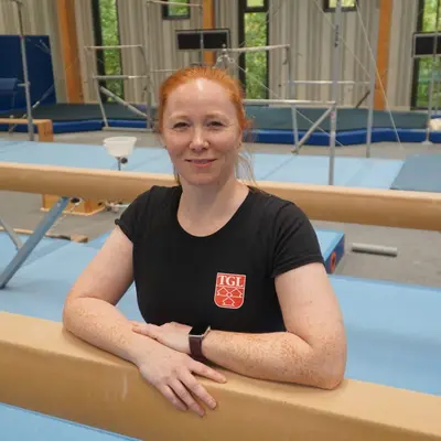 Eine Frau im roten T-Shirt der Turngemeinde Landshut lächelt in die Kamera.