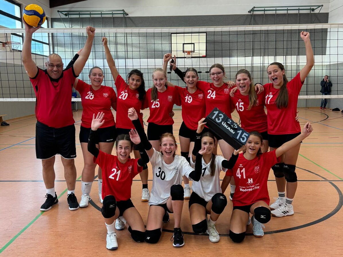 Die 3. Damenmannschaft des Turnvereins Landshut stehen in einheitlichen Trikots vor dem Volleyballnetz..