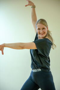 Eine Frau tanzt fröhlich in einem Fitnesskurs der Turngemeinde Landshut.