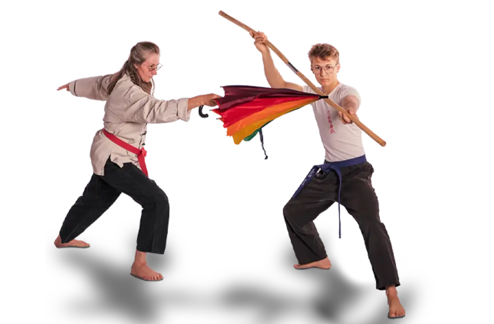 Zwei Personen führen in einer dynamischen Kung-Fu-Demonstration mit buntem Banner einen Sportauftritt für die Turngemeinde Landshut vor.