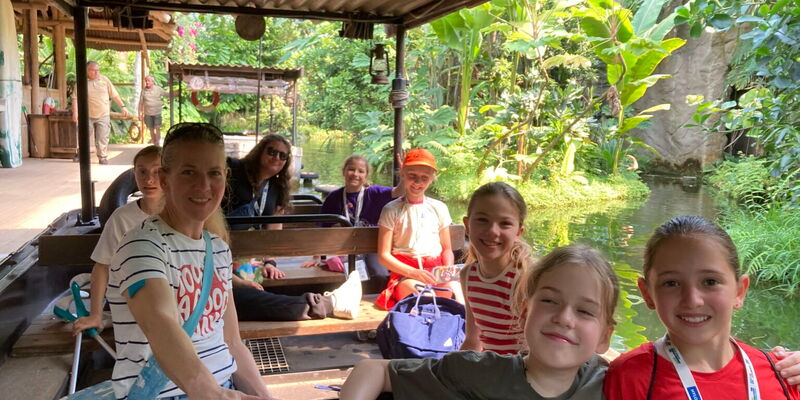 Eine Gruppe lächelnder Mädchen genießt eine Bootstour im Zoo, organisiert vom Turngemeinde Landshut Verein.