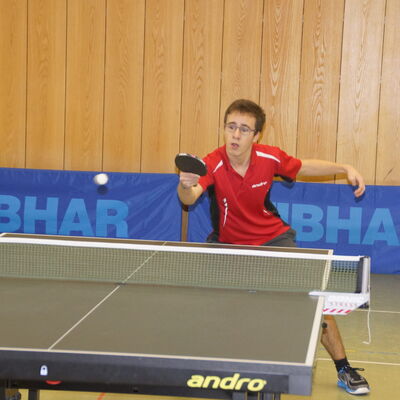 Ein Tischtennisspieler der Turngemeinde Landshut konzentriert sich auf einen Schlag in der Sporthalle.