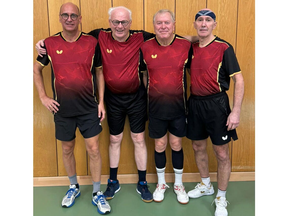 Vier Erwachsene in Sportkleidung posieren lächelnd in einer Turnhalle des Vereins Turngemeinde Landshut.