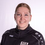 Eine lächelnde Person trägt eine schwarze Jacke mit TGL-Logo, die den Turnverein Landshut repräsentiert.