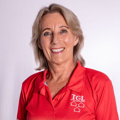Eine lächelnde Frau im roten TGL-Shirt präsentiert stolz ihre Zugehörigkeit zum Sportverein.