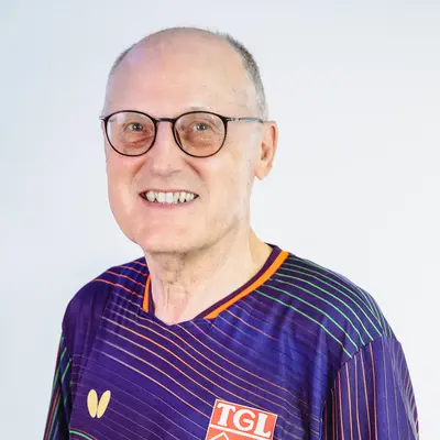 Der Abteilungsleiter der Tischtennis Abteilung trägt ein Trikot der Turngemeinde Landshut mit dem TGL-Logo.