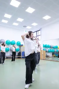 Eine Gruppe junger Frauen tanzt synchron in einem hellen Trainingsraum der Turngemeinde Landshut.