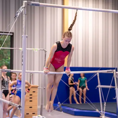 Eine Turnerin der Turngemeinde Landshut führt eine Übung am Stufenbarren in der Sporthalle aus.
