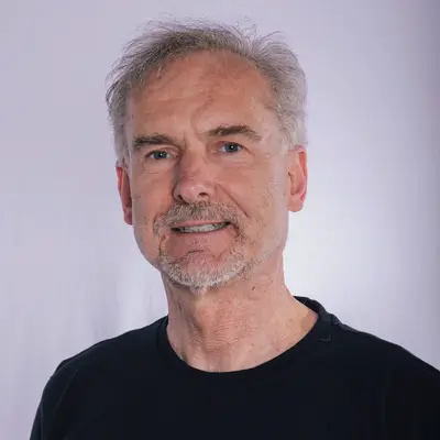 Ein Mann trägt ein schwarzes T-Shirt mit dem Logo der Turngemeinde Landshut, das stolz den Sportverein repräsentiert.