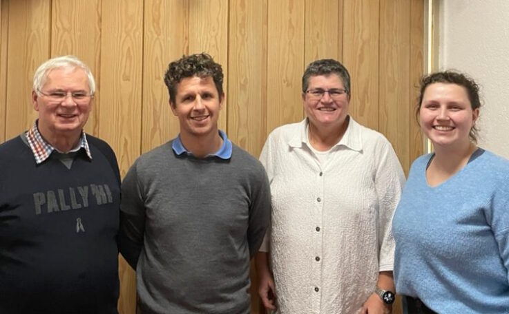 Vier Personen stehen lächelnd vor einer Holzwand und repräsentieren die neue Abteilungsleitung des Turnvereins Landshut.
