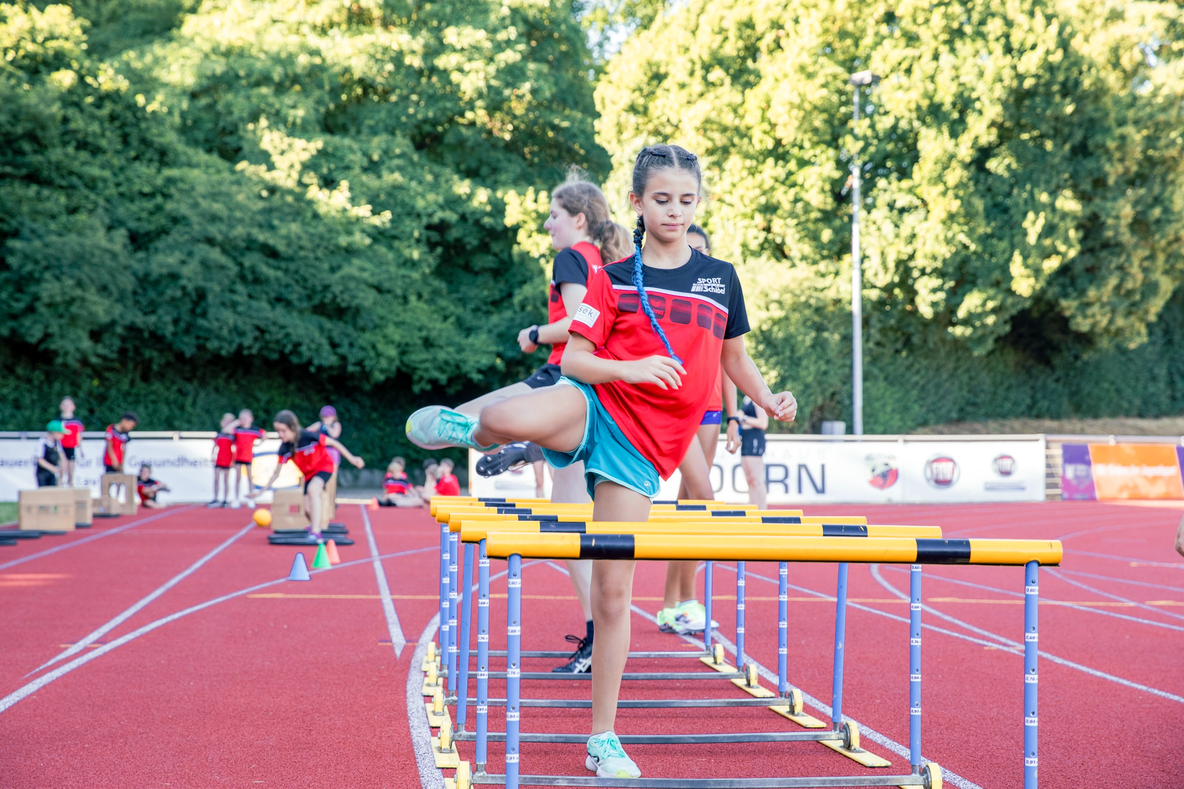 Ein Mädchen überspringt Hürden auf der Tartanbahn des Sportvereins Turngemeinde Landshut.