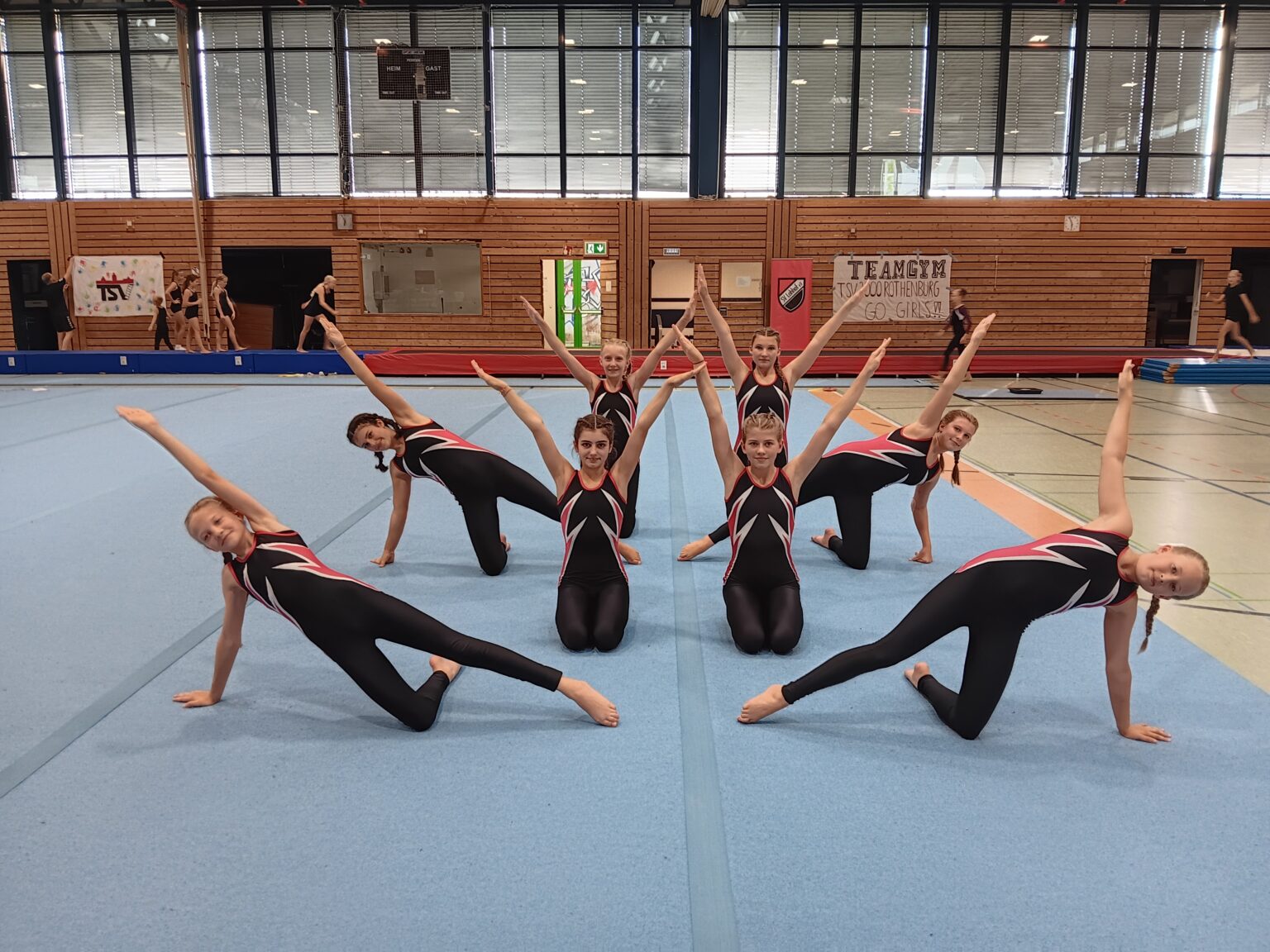 Eine Gruppe junger Turnerinnen der Turngemeinde Landshut zeigt eine Bodenübung in der Sporthalle.