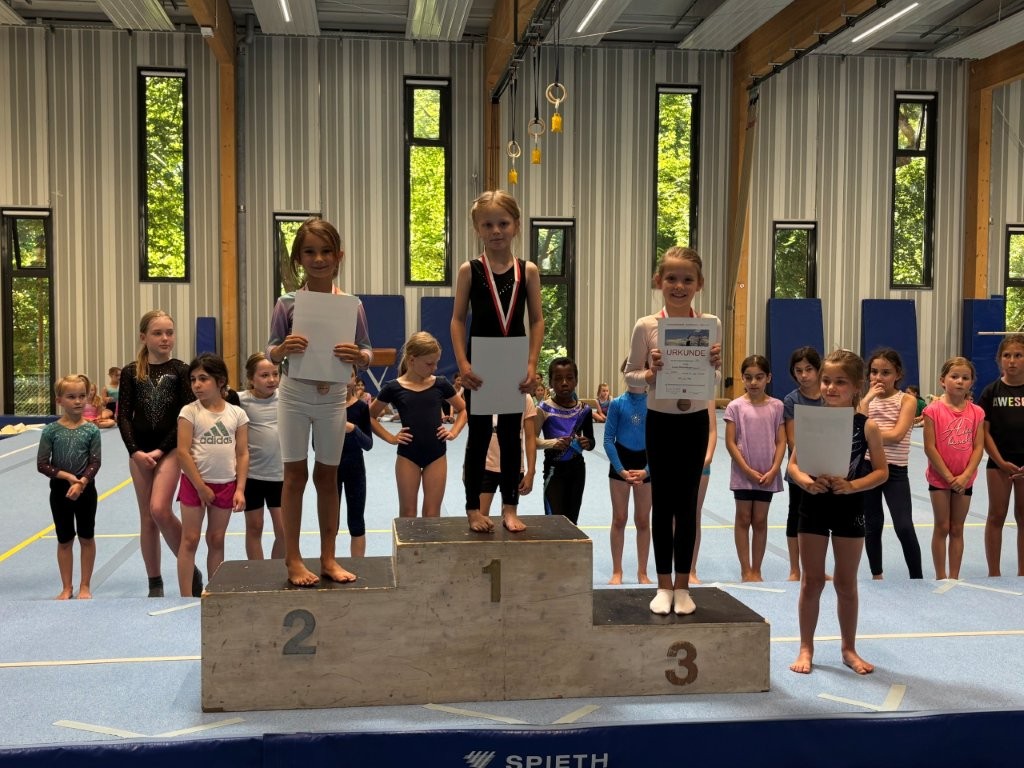 Kinder der Turngemeinde Landshut stehen stolz auf dem Siegerpodest ihrer Sportveranstaltung im Jahrgang 2018.